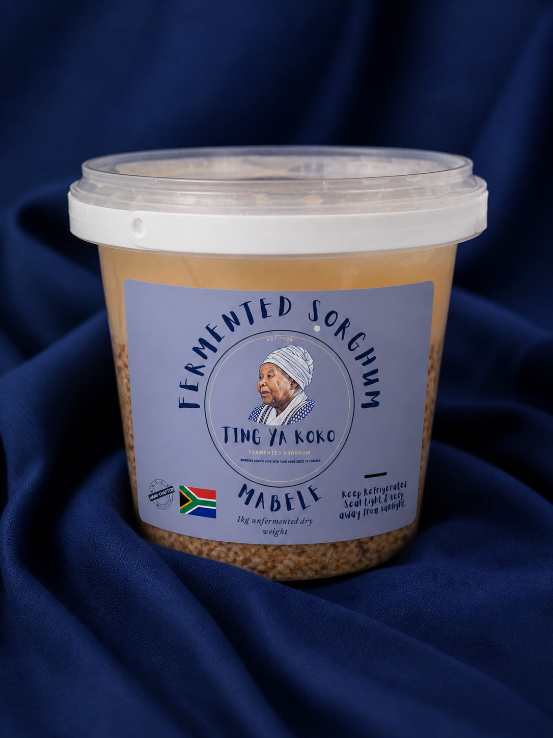 A tub of Ting Ya Koko fermented sorghum mabele on draped navy cloth